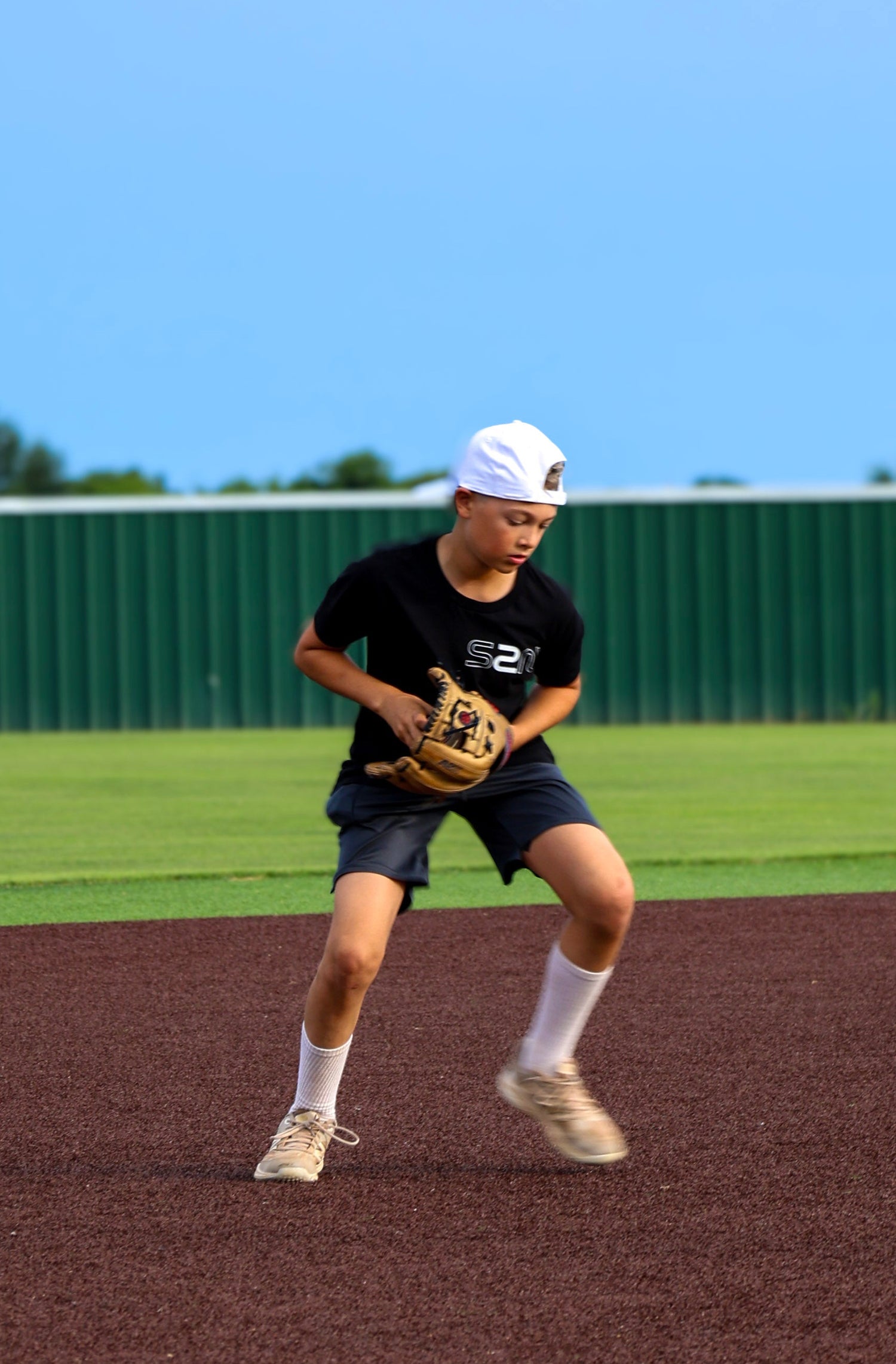 Person in a baseball uniform on a field with a clear blue sky

